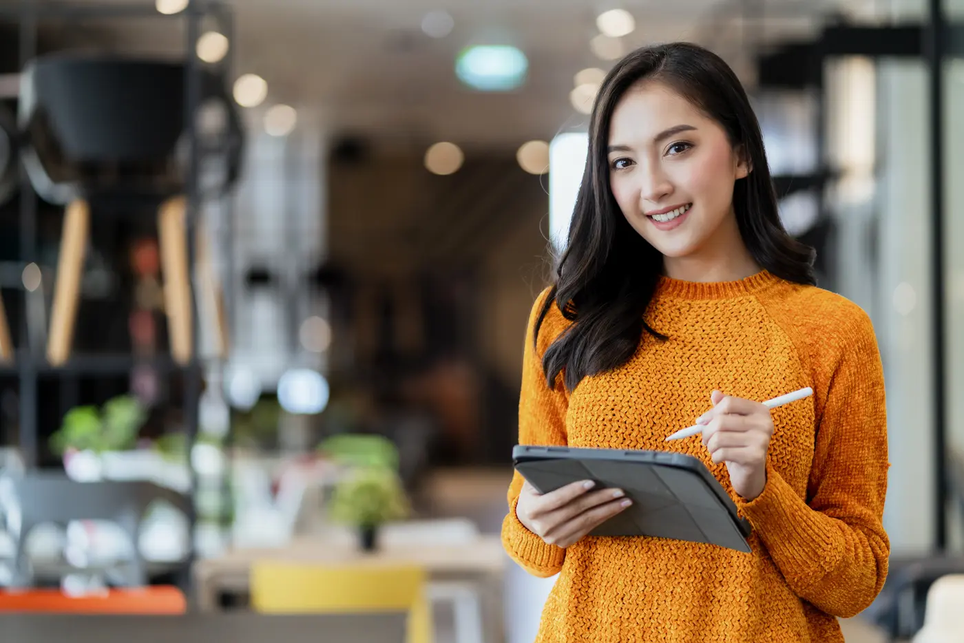 Una emprendedora revisa su inventario en una tableta en su tienda