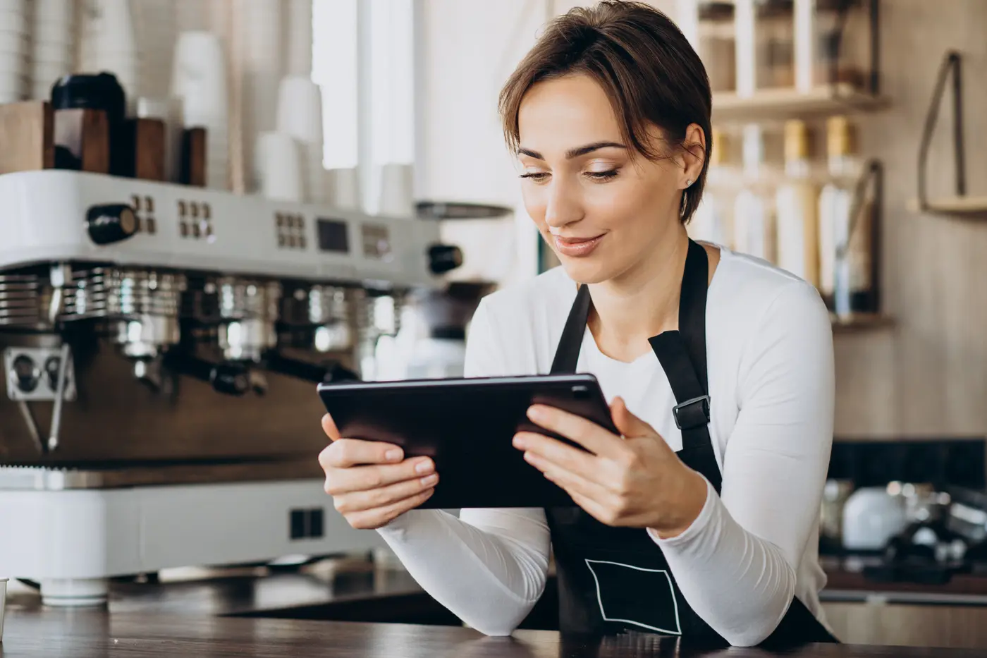 Una barista toma un pedido con una tableta en su cafetería